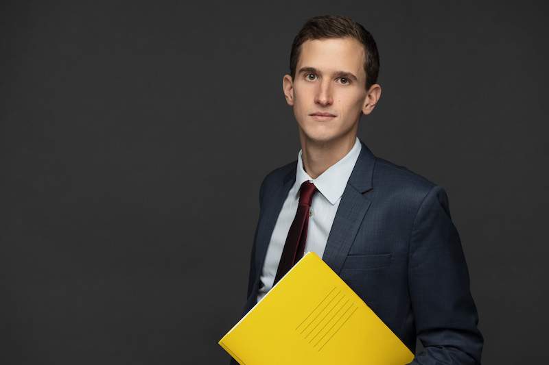 Bild von Alexander Krosswang mit Gutachen und Dokument in der Hand.